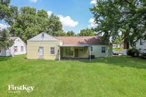 Kansas City house for rent - a white and yellow house with a yard and trees