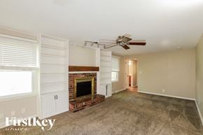 Overland Park house for rent - A living room with a fireplace and a fan.