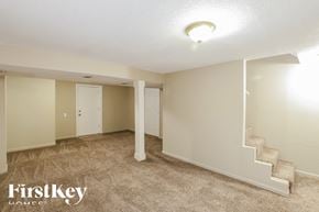 Overland Park house for rent - A spacious room with a staircase and a carpeted floor.