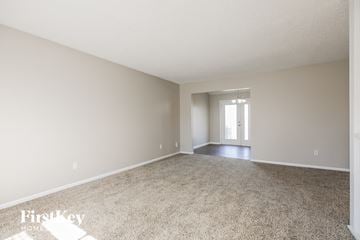 Kansas City house for rent - a spacious living room with carpet and a door to the dining room