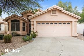 Peoria house for rent - A house with a pinkish facade and a large garage door.