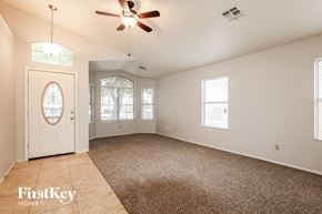 Peoria house for rent - A spacious room with a carpeted floor and a ceiling fan.