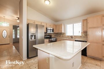 Peoria house for rent - A kitchen with a white counter top and wooden cabinets.
