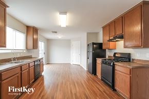 Baytown house for rent - an empty kitchen with wood flooring and black appliances