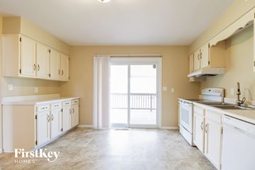 West Chester house for rent - a kitchen with white cabinets and a door to a balcony