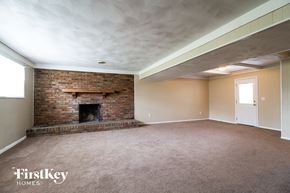 West Chester house for rent - a living room with a brick fireplace and a carpeted floor