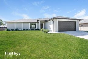 Fort Myers house for rent - a white house with a lawn and a garage door
