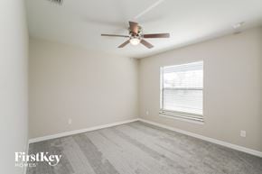 Fort Myers house for rent - a bedroom with a ceiling fan and a window