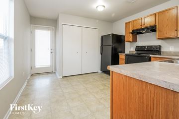 Camby house for rent - a kitchen with wood cabinets and a black refrigerator and a sink