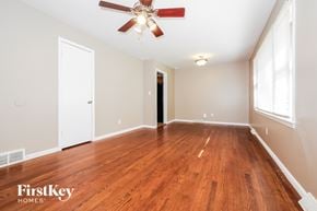 Raytown house for rent - A room with wooden floors and a ceiling fan.