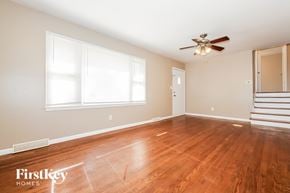 Raytown house for rent - A room with wooden floors and a ceiling fan.