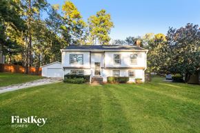 Charlotte house for rent - the front of a white house with a lawn and a driveway