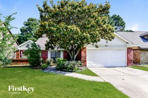 Humble house for rent - a white garage door in front of a brick house