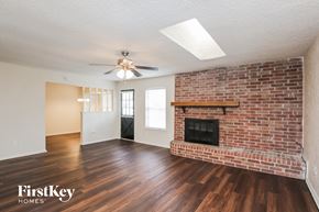 North Richland Hills house for rent - A room with a brick fireplace and wooden floors.