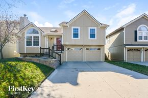 Kansas City house for rent - a beige house with two garage doors and a driveway