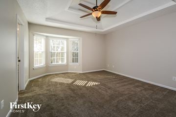 Kansas City house for rent - a living room with carpet and a ceiling fan