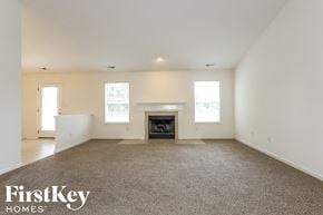 Avon house for rent - A spacious living room with a fireplace and carpeted floor.