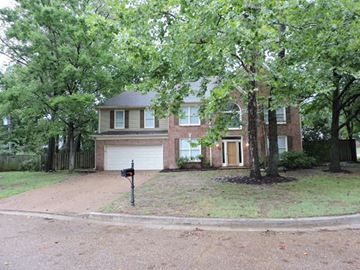 Cordova house for rent - a brick house with a driveway and trees