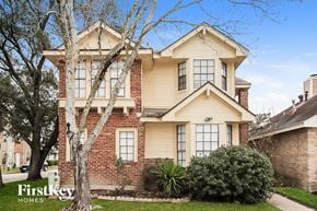 Houston house for rent - a brick and cream colored house with a tree in front of it