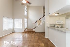 Houston house for rent - an open kitchen and living room with a staircase and a window