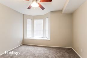 Houston house for rent - a bedroom with a large window and a ceiling fan