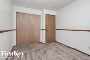 Indianapolis house for rent - a bedroom with a carpeted floor and two closet doors