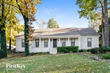 Cordova house for rent - the front of a white house with a yard and trees
