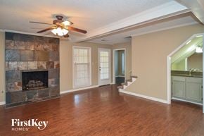 Cordova house for rent - a living room with a fireplace and a ceiling fan