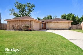 Humble house for rent - a home with a lawn and a garage and a driveway
