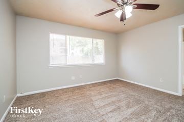 Humble house for rent - the spacious living room with carpet and a ceiling fan