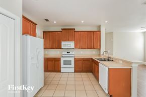 Riverview house for rent - a kitchen with white appliances and wooden cabinets