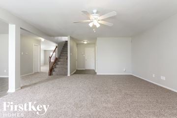 Camby house for rent - a spacious living room with carpet and a ceiling fan