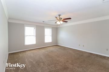 Cordova house for rent - a living room with carpet and a ceiling fan