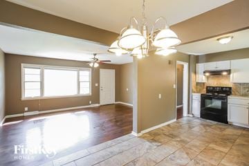 Raytown house for rent - A kitchen area with a stove and oven, and a dining area with a table and chairs.