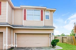 Houston house for rent - a house with a garage door and a lawn