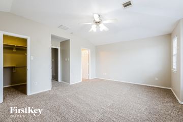 Houston house for rent - a spacious living room with carpet and a ceiling fan