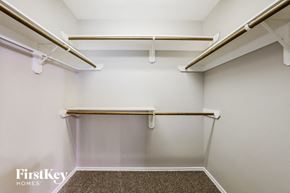 Houston house for rent - a spacious walk in closet with empty shelves and hooks