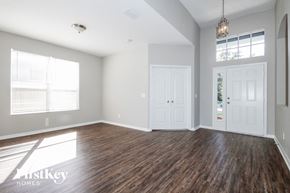 Riverview house for rent - an empty living room with wood floors and white doors