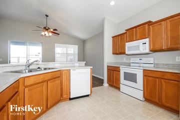 Riverview house for rent - a kitchen with wooden cabinets and white appliances and a sink