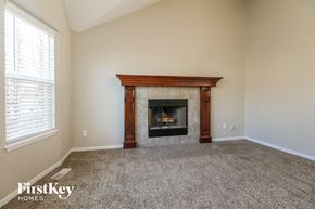 Kansas City house for rent - A room with a fireplace and a carpeted floor.