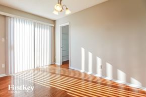 Kansas City house for rent - A room with wooden floors and a sliding door.
