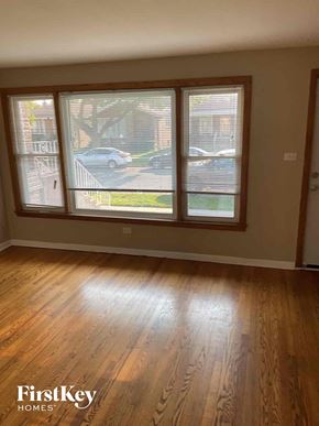 Chicago house for rent - an empty living room with a hard wood floor and large windows