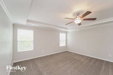 Charlotte house for rent - a living room with a ceiling fan and a carpet