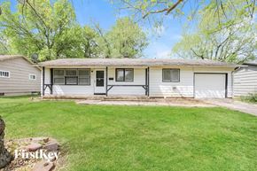 Kansas City house for rent - a white house with a grassy yard and a garage