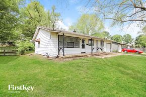 Kansas City house for rent - a white house with a lawn and a red car in the background
