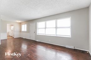 Kansas City house for rent - an empty living room with wood floors and a large window
