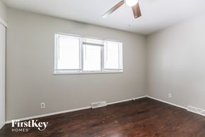Kansas City house for rent - a bedroom with wood flooring and a window and a ceiling fan