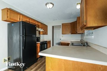 Indianapolis house for rent - a kitchen with black appliances and wooden cabinets