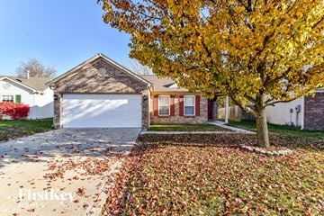 Camby house for rent - a house with a white garage door and a tree in front of it