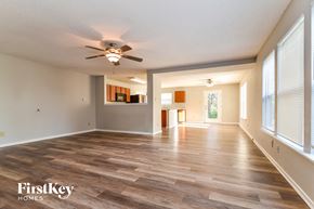 Camby house for rent - an empty living room with a ceiling fan and a large window